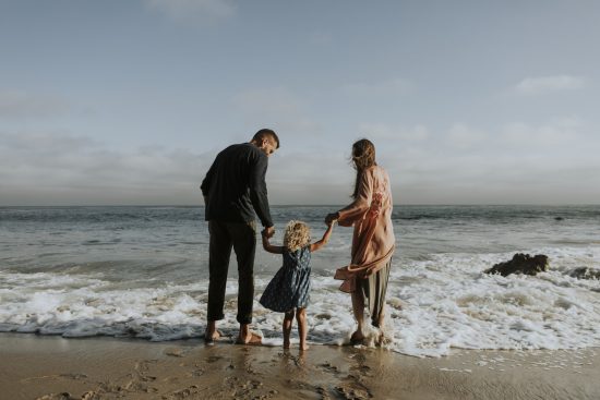 child with parents at the sea side